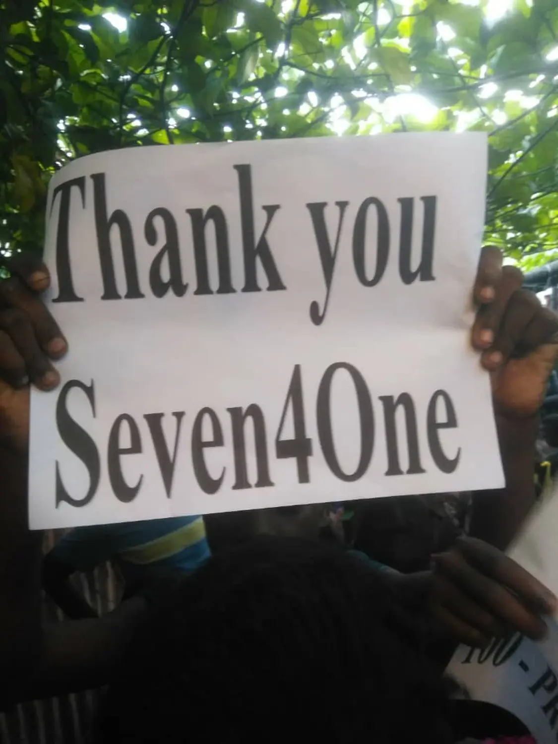 Seven4ONE - Kinder halten ein bedrucktes „Thank You Seven4ONE e.V.“-Papier in der Hand