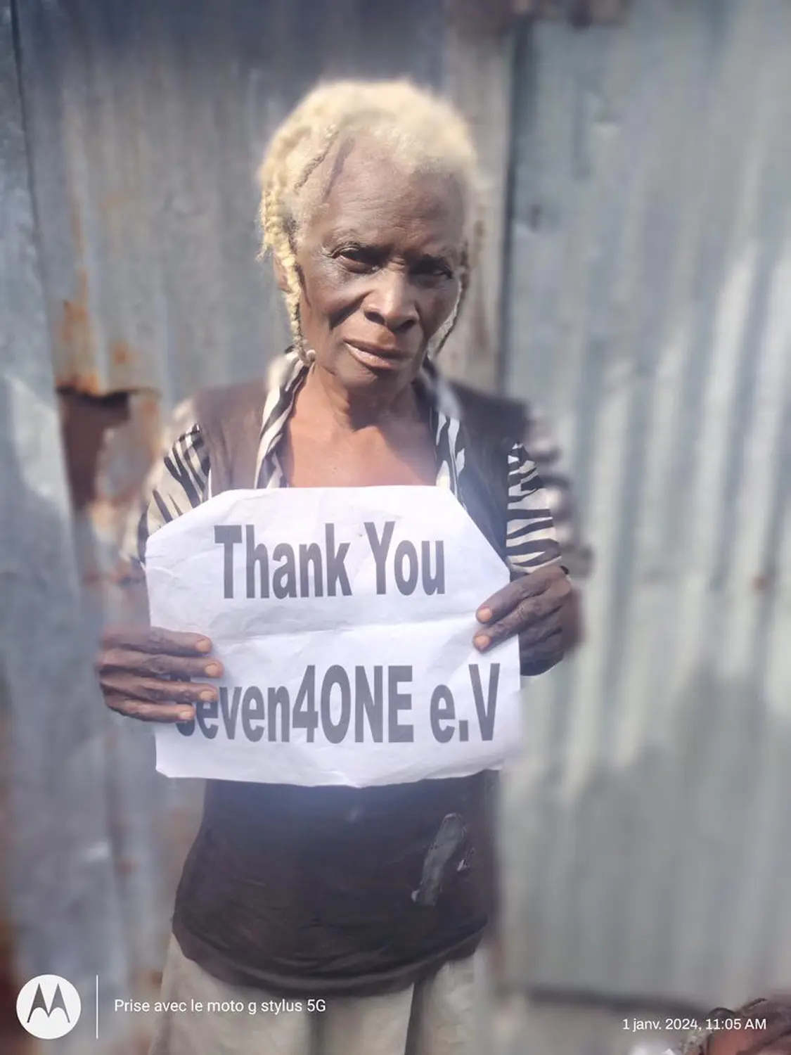 Seven4ONE - eine alte Dame hält ein bedrucktes „Thank You Seven4ONE e.V.“-Papier in der Hand